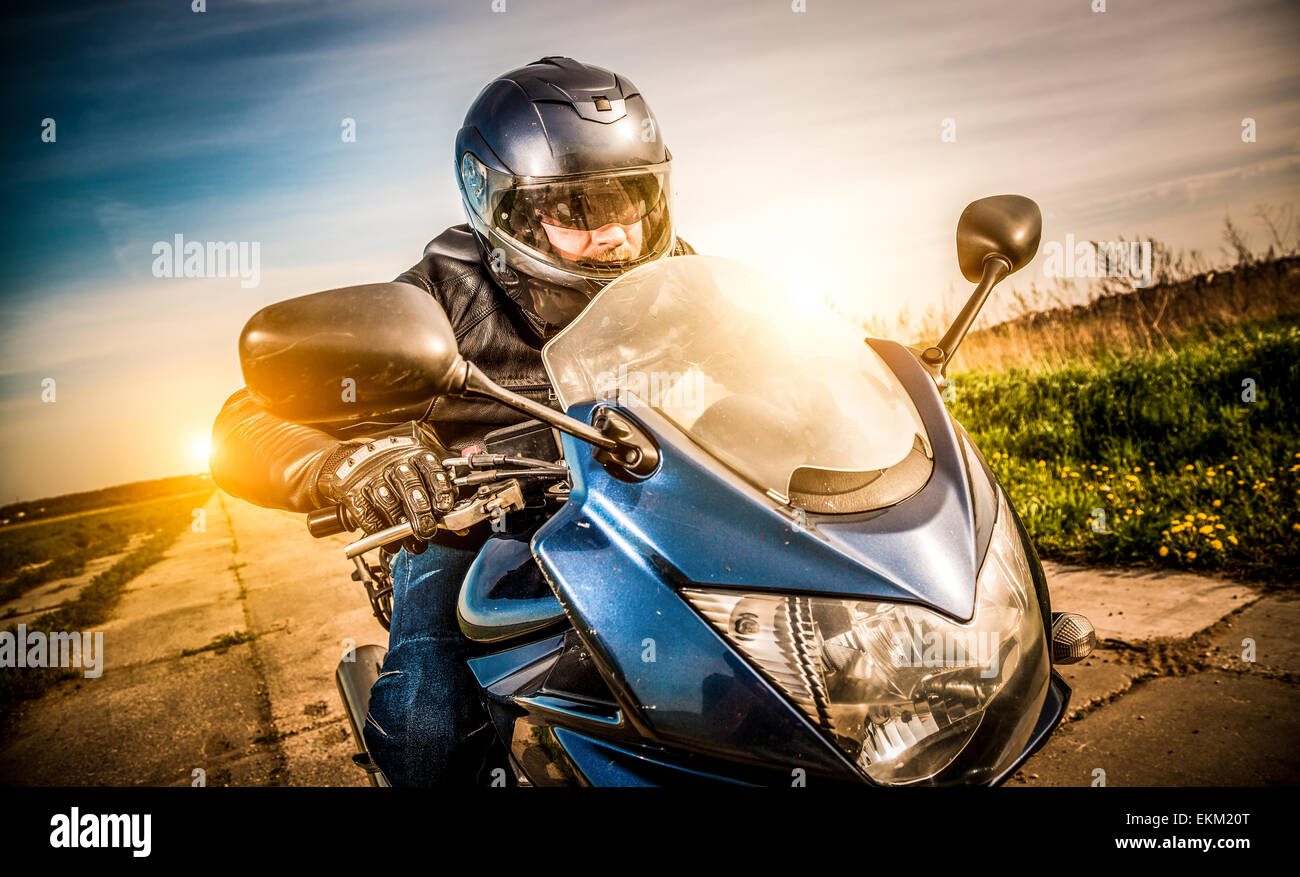 Biker in casco e giacca di pelle racing su strada Foto Stock Biker in casco e giacca di pelle racing su strada Foto Stock