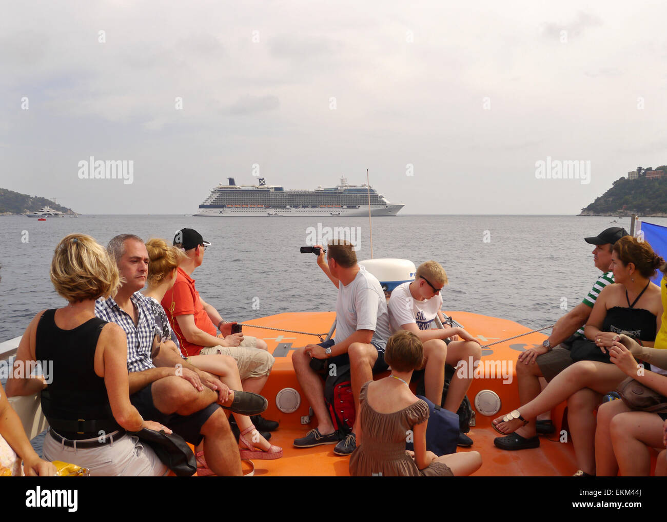 Un gruppo di turisti su una nave di tenera con il celebrity Equinox in background Foto Stock