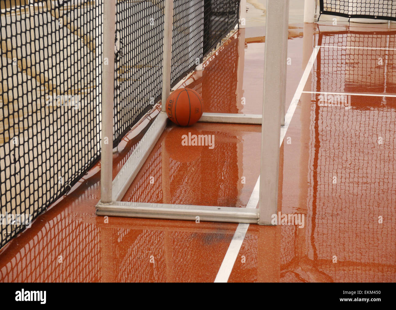 Una palla da basket giacente in un obiettivo di calcio su un umido e deserte giudice sportivo su una nave da crociera Foto Stock