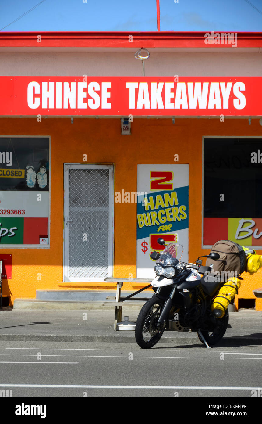 Ciclo del motore al di fuori del rosso e giallo take away cinese e di pesce e di Chip shop, Sanson, Manawatu Affitto, Isola del nord, Nuova Zelanda Foto Stock