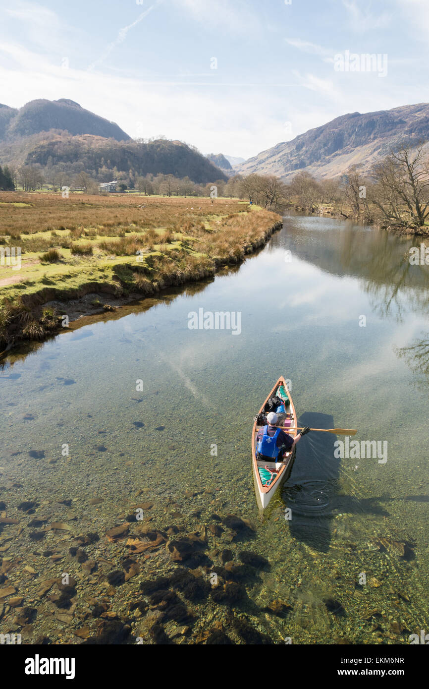 Uomo e cane visto dal Ponte cinese paddling in canoa lungo il fiume Derwent vicino a Derwentwater nel Lake District inglese Foto Stock