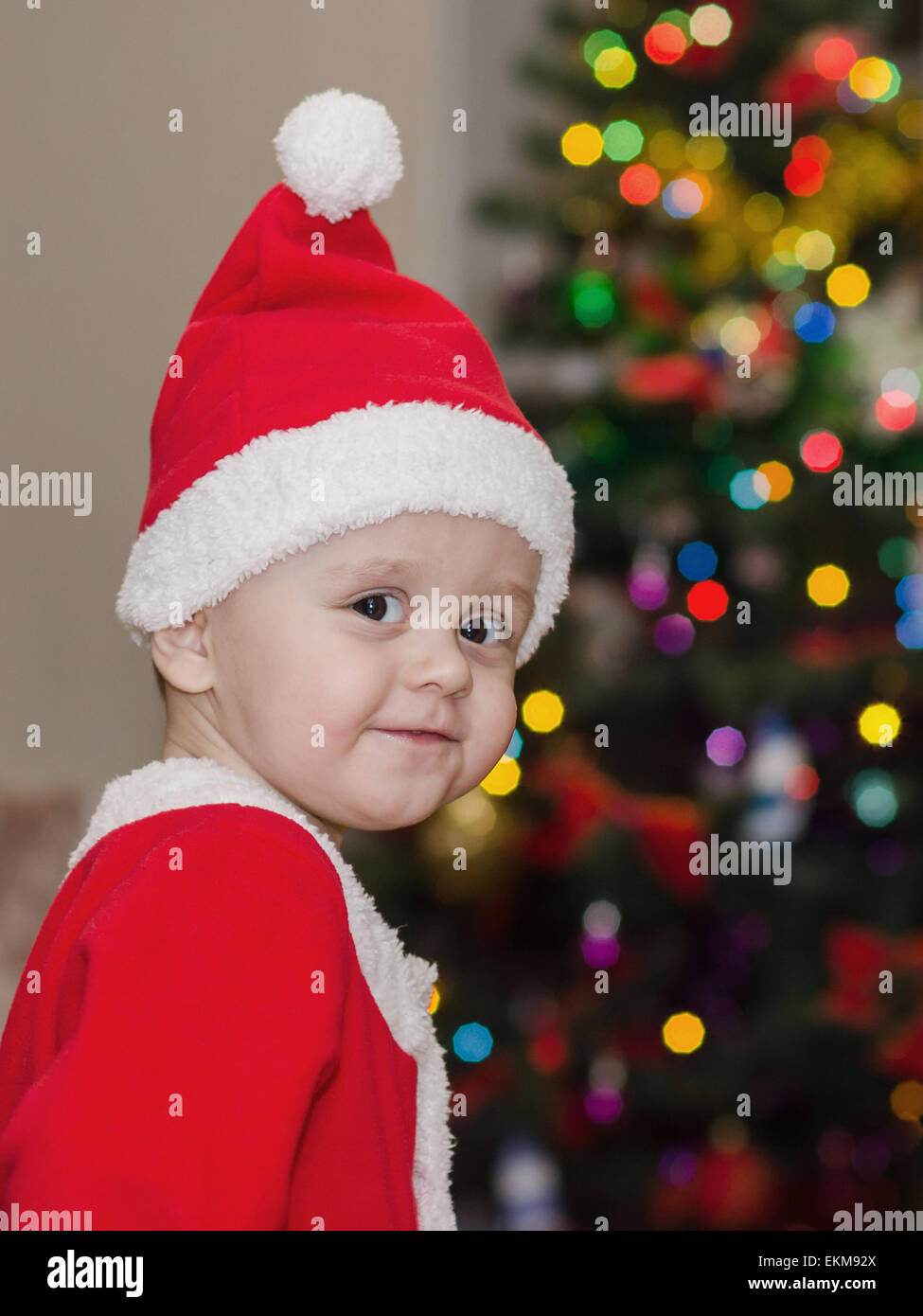 Bambino vestiti da Babbo Natale in piedi vicino all albero di Natale Foto  stock - Alamy
