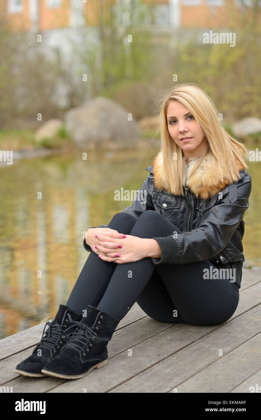Giovane donna indossa leggings seduti ad un laghetto in primavera Foto  stock - Alamy