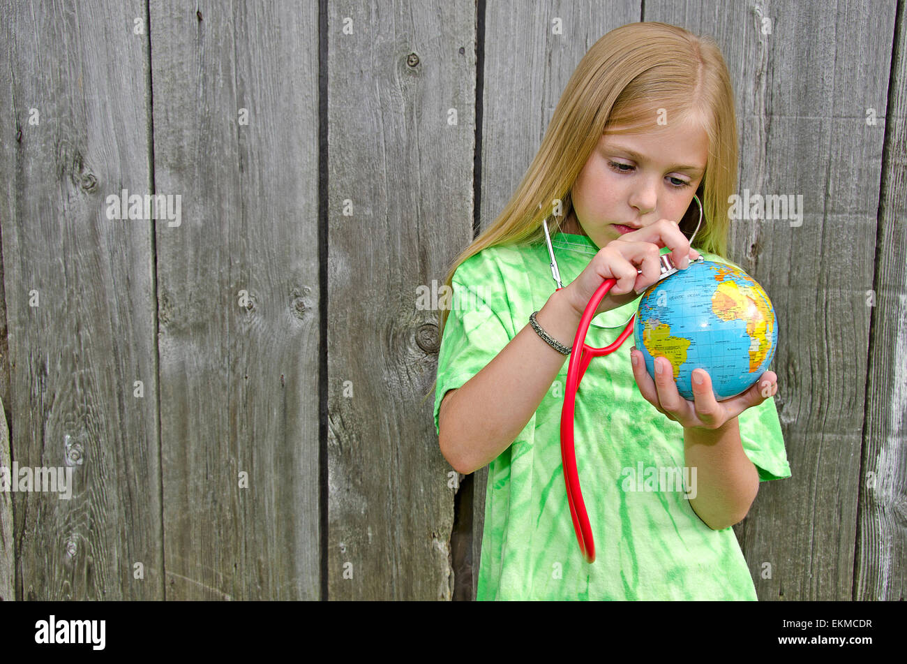 Giovane ragazza caucasica con uno stetoscopio su un globo mondo nella sua mano. Foto Stock