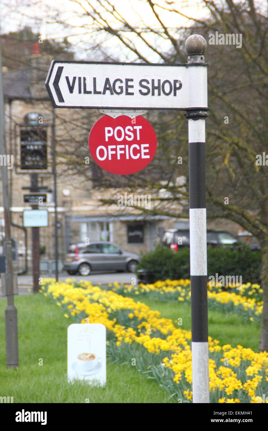 Un cartello indica la strada per un ufficio postale di una zona rurale e village store a Baslow,Parco Nazionale di Peak District, Derbyshire - molla Foto Stock