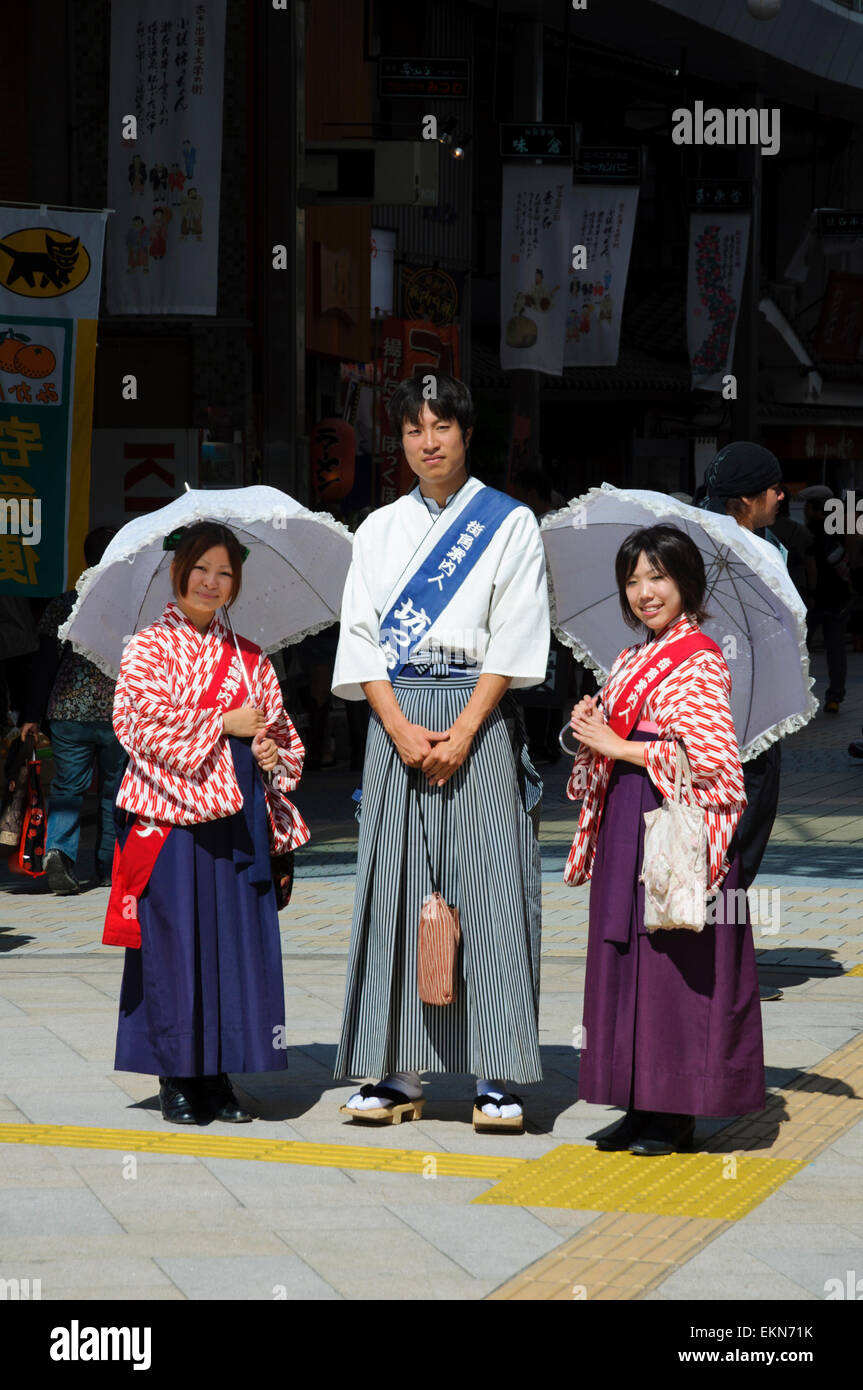 Un giovane giapponese persone promozionali in costume tradizionale, promuovendo la città di Matsuyama, Giappone. Kimono, kimono, ombrelloni, giovane uomo, donne Foto Stock