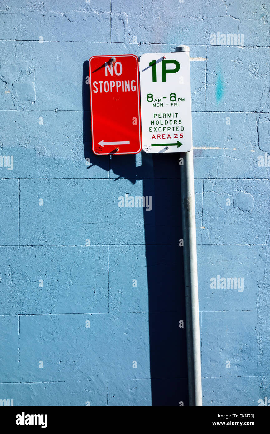 Parcheggio segni - nessun arresto, parcheggio limitato segno contro una parete di blu. Le restrizioni per il parcheggio; nessun parcheggio; regolamenti e norme; parcheggio vietato; Foto Stock