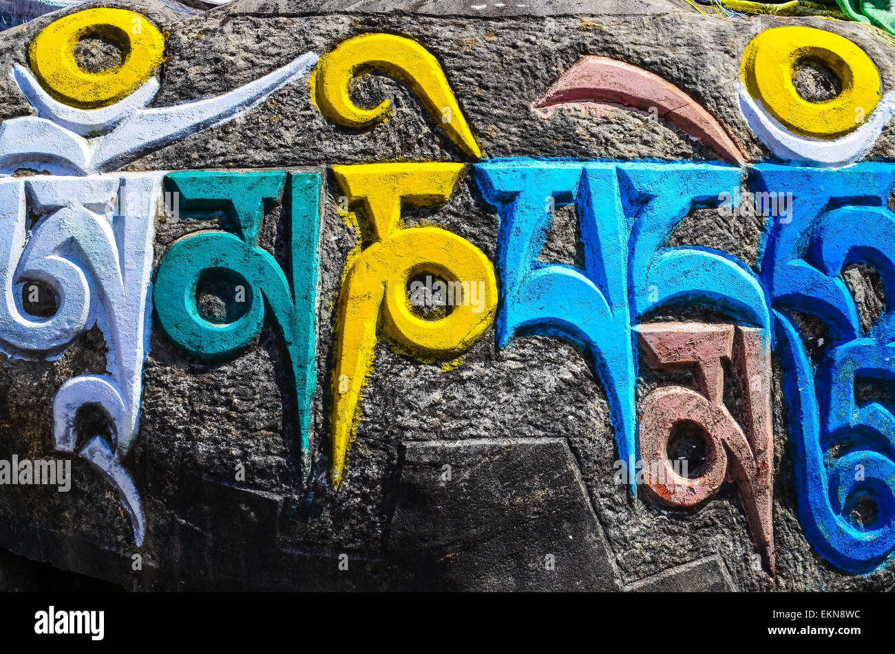 Buddista Tibetana simboli religiosi sulle pietre Foto Stock