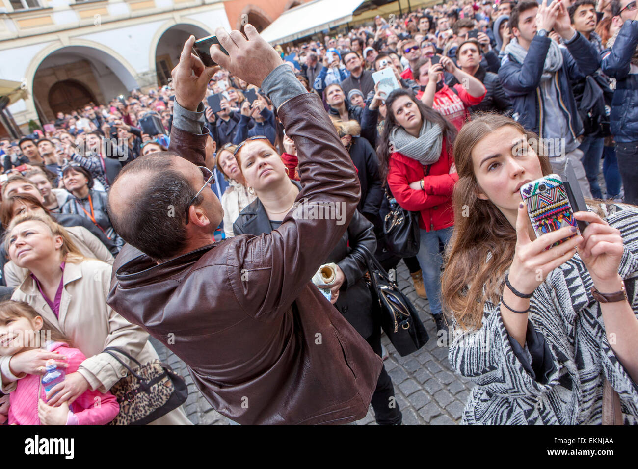 Una folla di turisti Praga guarda l'orologio astronomico, la Piazza della città Vecchia, la folla di gente della Repubblica Ceca, l'Europa che usa il telefono cellulare Foto Stock