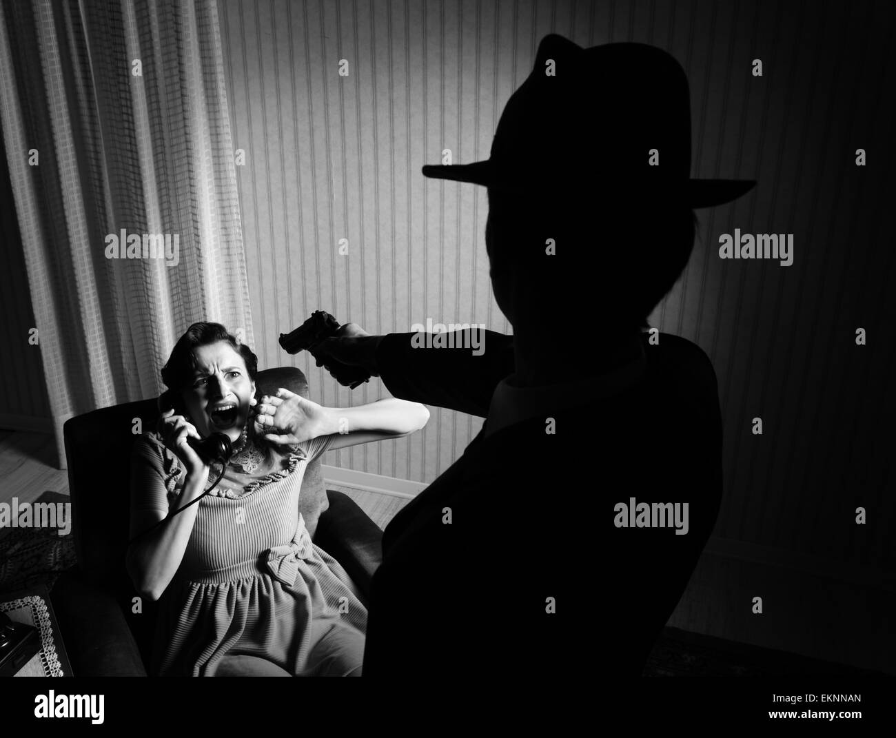 Killer puntando la pistola ad una donna terrorizzata Foto Stock