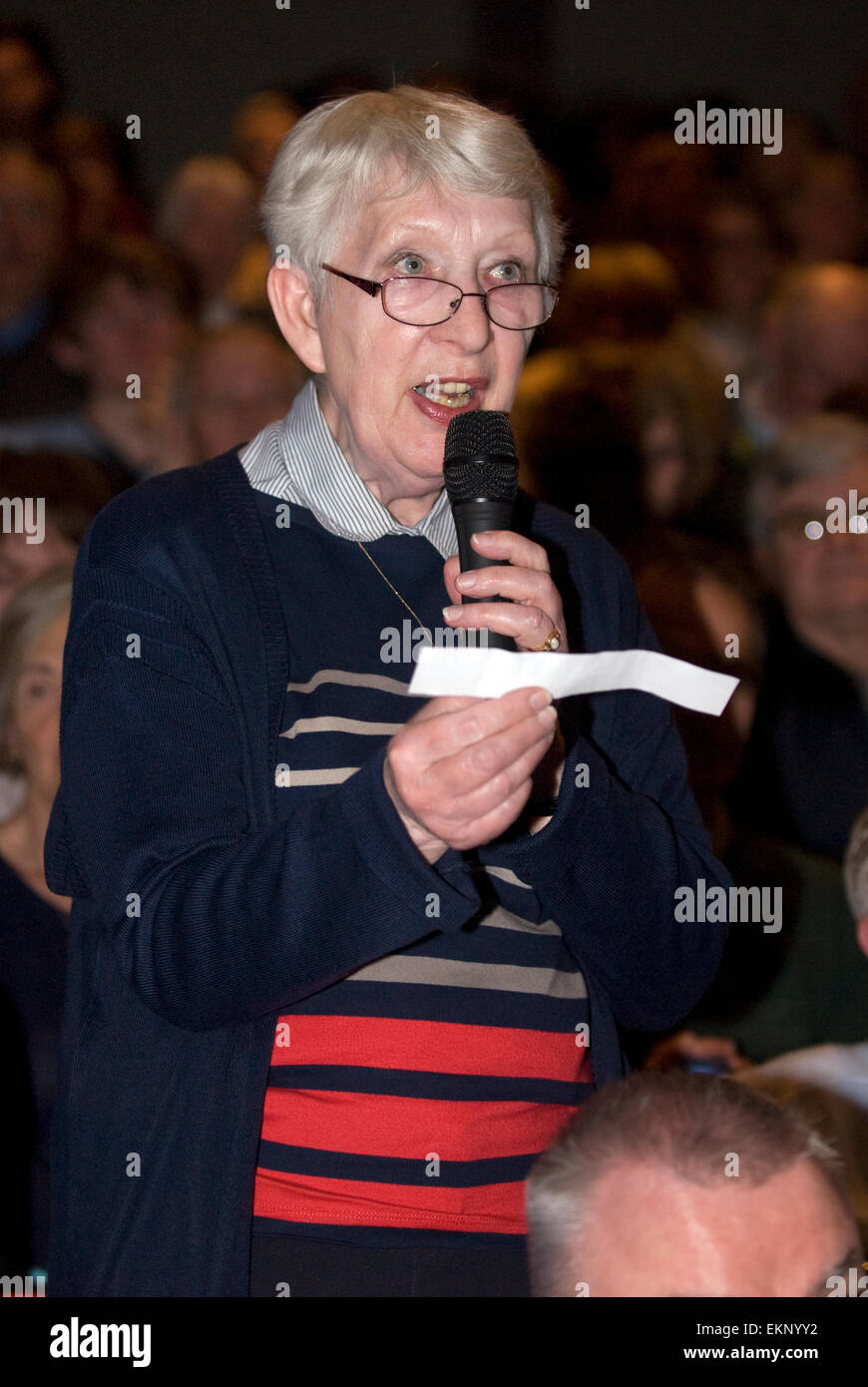 Donna anziana che pongono una questione ad un pannello di politici a un evento hustings prima delle elezioni generali britanniche il 7 maggio 2015... Foto Stock