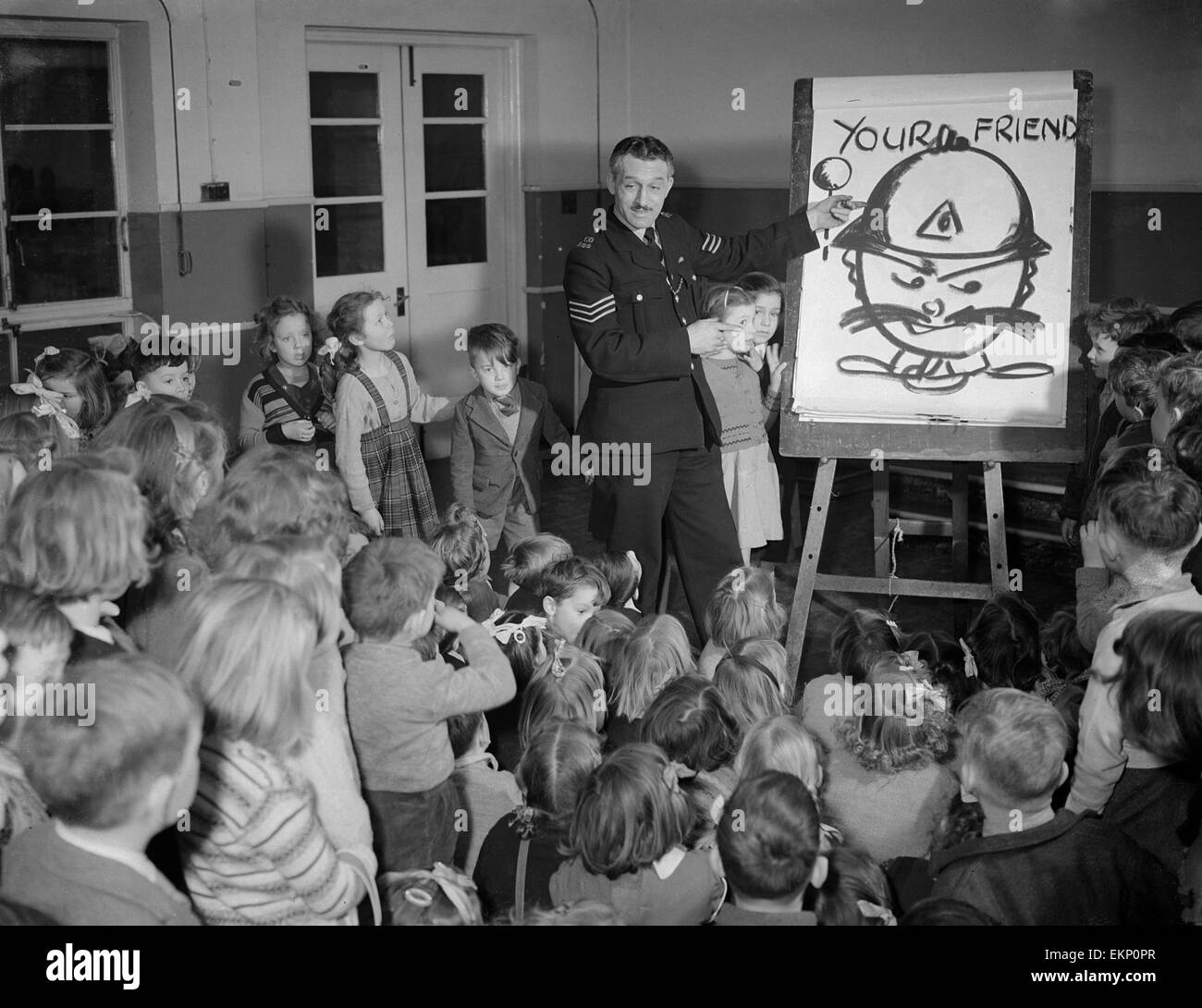 I bambini che ricevono una sicurezza stradale lezione da un poliziotto durante una classe a scuola. Il 24 giugno 1952. Foto Stock