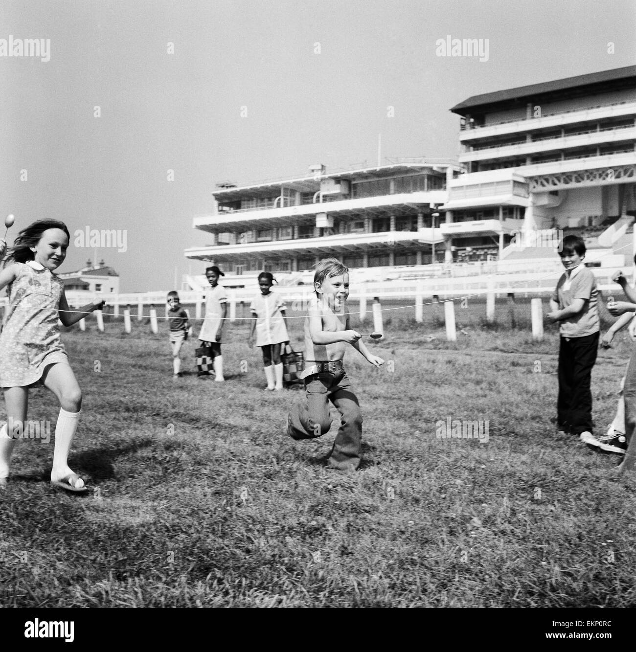 Bambini gara tutta la linea del traguardo dell'uovo e cucchiaio gara sulle Downs presso la Epsom dove gli allenatori dei bambini hanno avuto una vacanza lontano dal Peckham. La giornata è stata organizzata dalla Peckham insediamento. Surrey, 16 agosto 1973. Foto Stock