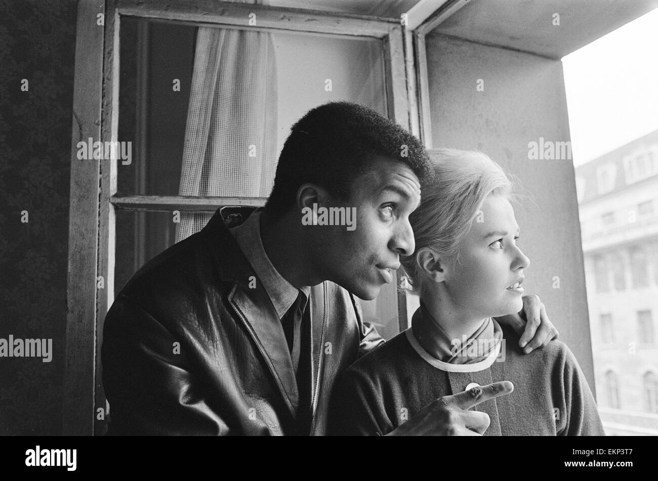 Cantante pop Kenny Lynch con Elaine Miscall, Nuova Zelanda, il partecipante al concorso di Miss Mondo. Essi si sono incontrati presso l'Hotel Waldordt dove egli ha messo in evidenza alcune delle pietre miliari locali e punti di interesse dalla finestra. Il 30 ottobre 1963. Foto Stock