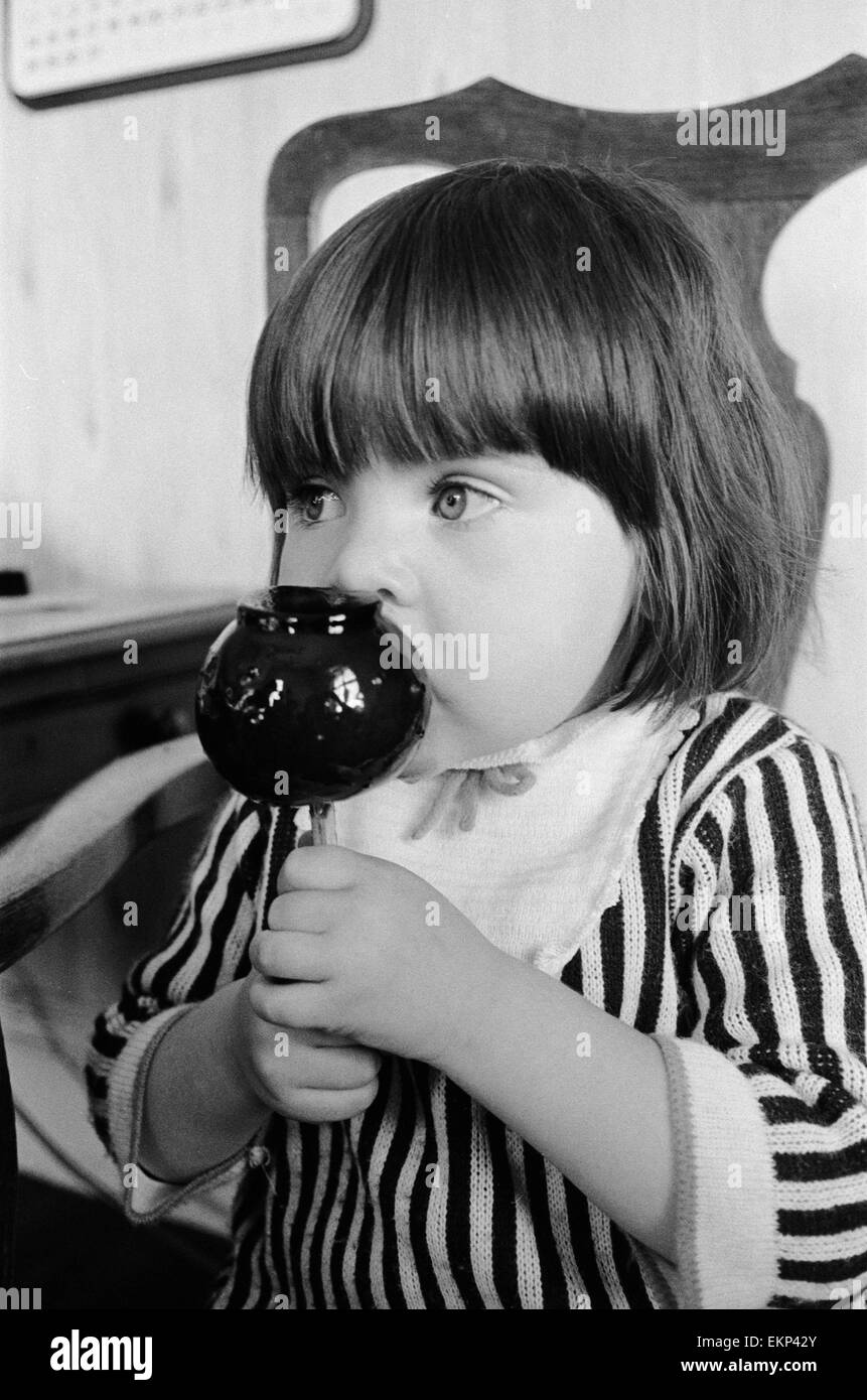 Due anni di Tracey Emmanuel di Wembley, Londra, campioni di un vecchio inglese toffee apple dalla nonna fabbrica nel Bedfordshire. Il 7 ottobre 1968. Foto Stock