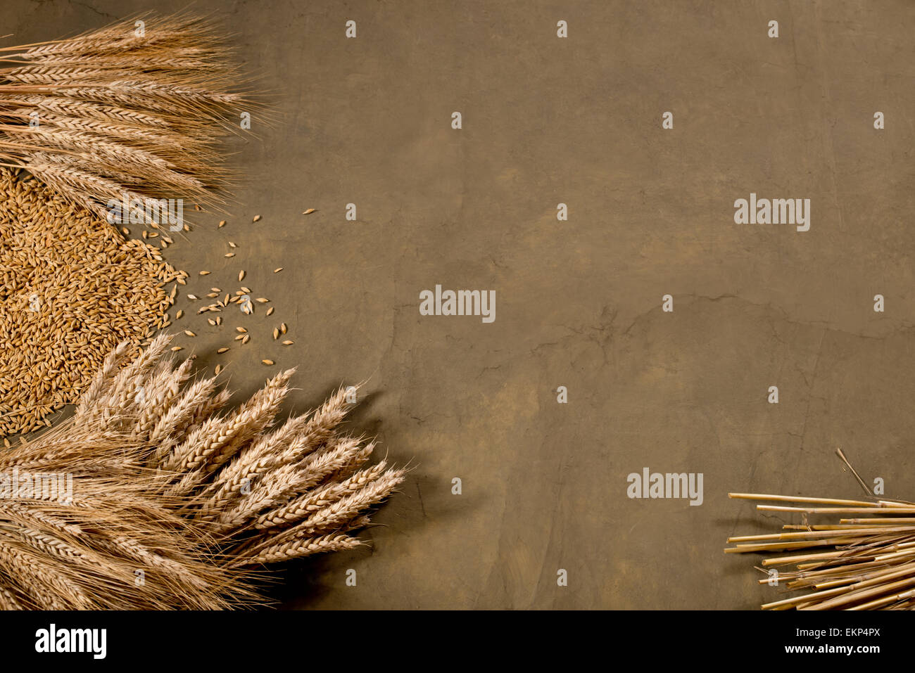 Un covone di grano ed orzo sulla scrivania scuro Foto Stock