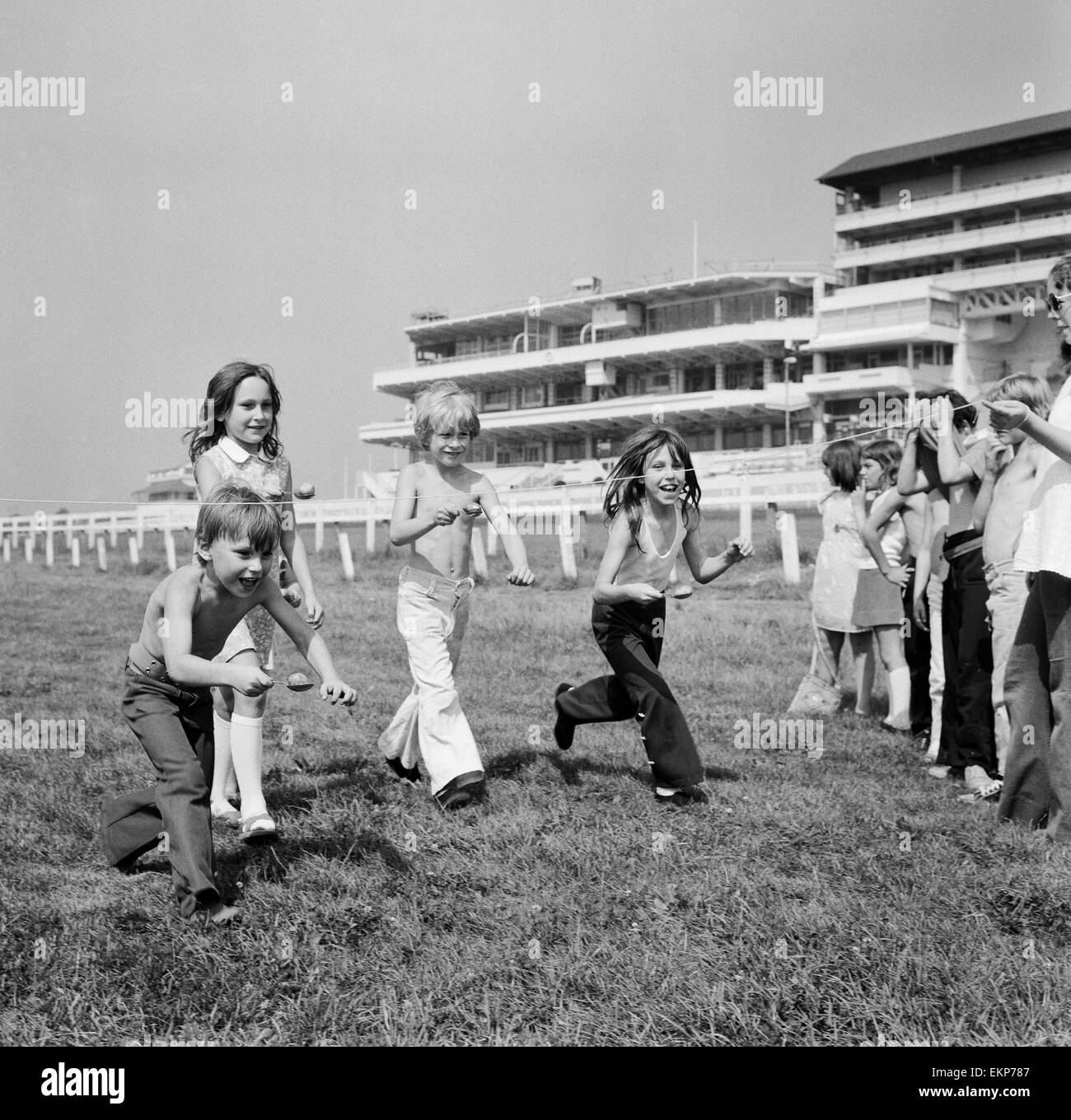 Bambini gara tutta la linea del traguardo dell'uovo e cucchiaio gara sulle Downs presso la Epsom dove gli allenatori dei bambini hanno avuto una vacanza lontano dal Peckham. La giornata è stata organizzata dalla Peckham insediamento. Surrey, 16 agosto 1973. Foto Stock
