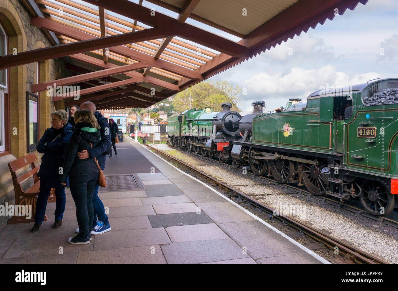 Treno a vapore, vecchi treni e banchina presso la stazione ferroviaria West Somerset, Minehead, Regno Unito Foto Stock