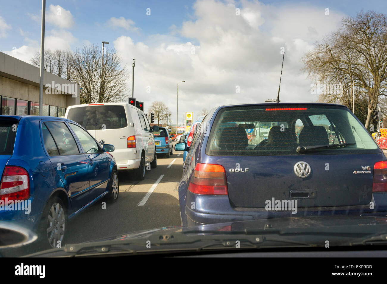 Traffico di automobili in coda al semaforo con lavori in corso sulle strade di una città, England, Regno Unito Foto Stock