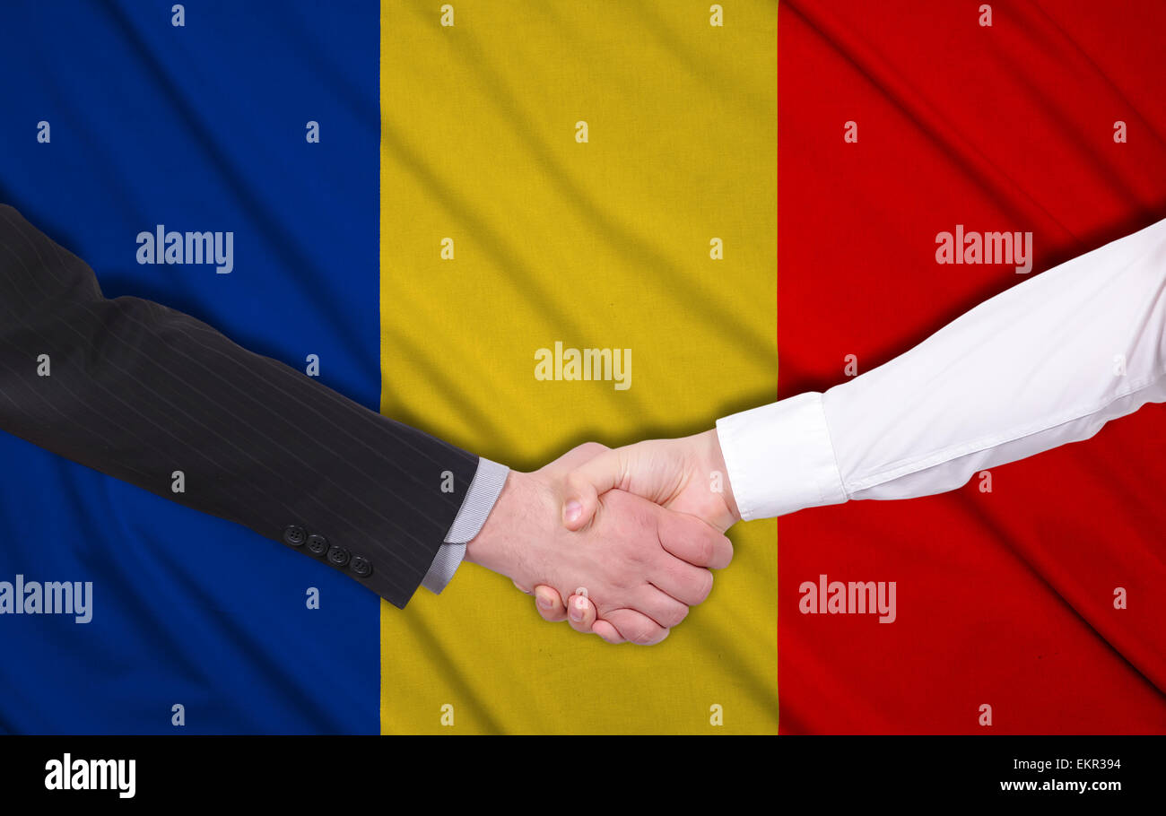 Due imprenditori stringono le mani sulla bandiera della Romania lo sfondo Foto Stock