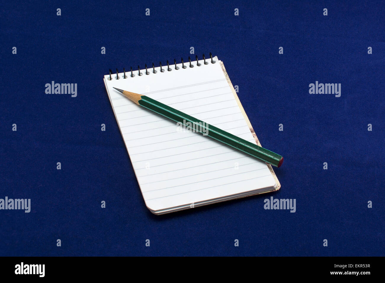 Una nota di libro con una matita verde. Foto Stock
