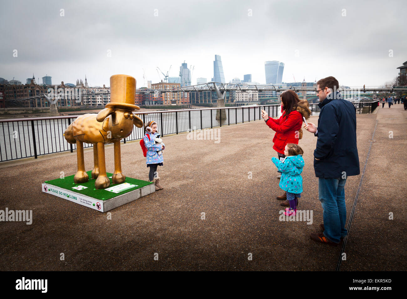I genitori fotografare il loro bambino da uno dei Shaun nella città sculture lungo il Tamigi a Londra Foto Stock