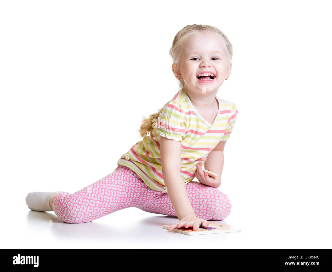 Sorridente ragazza di capretto risolvendo puzzle Foto Stock