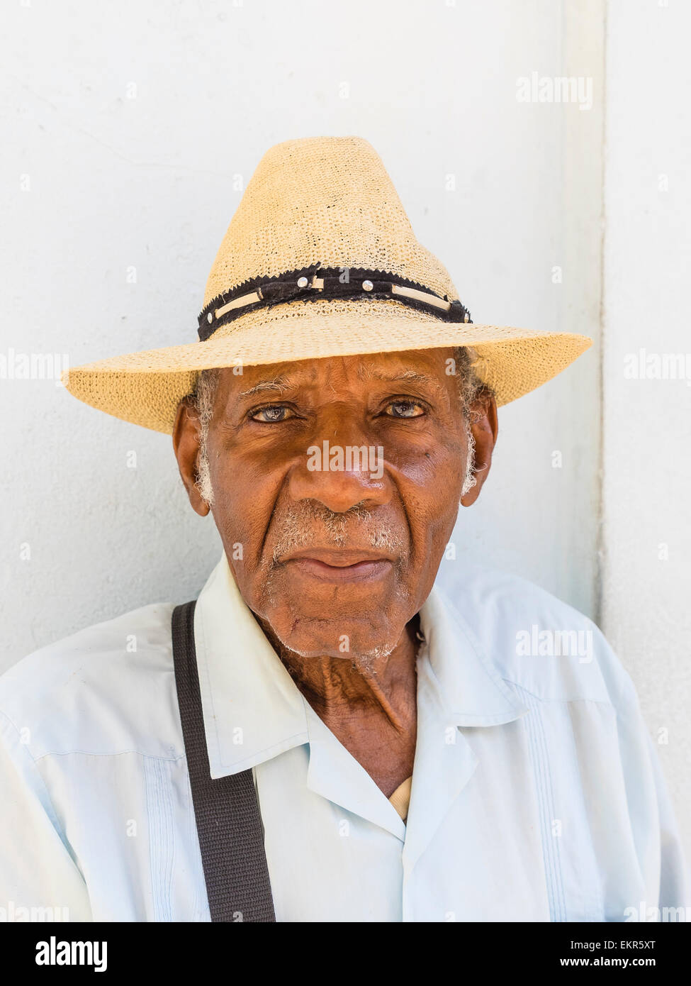 Testa e spalle ritratto di un maschio di afro-cubane senior citizen nel cappello di paglia rivolto in avanti. Foto Stock