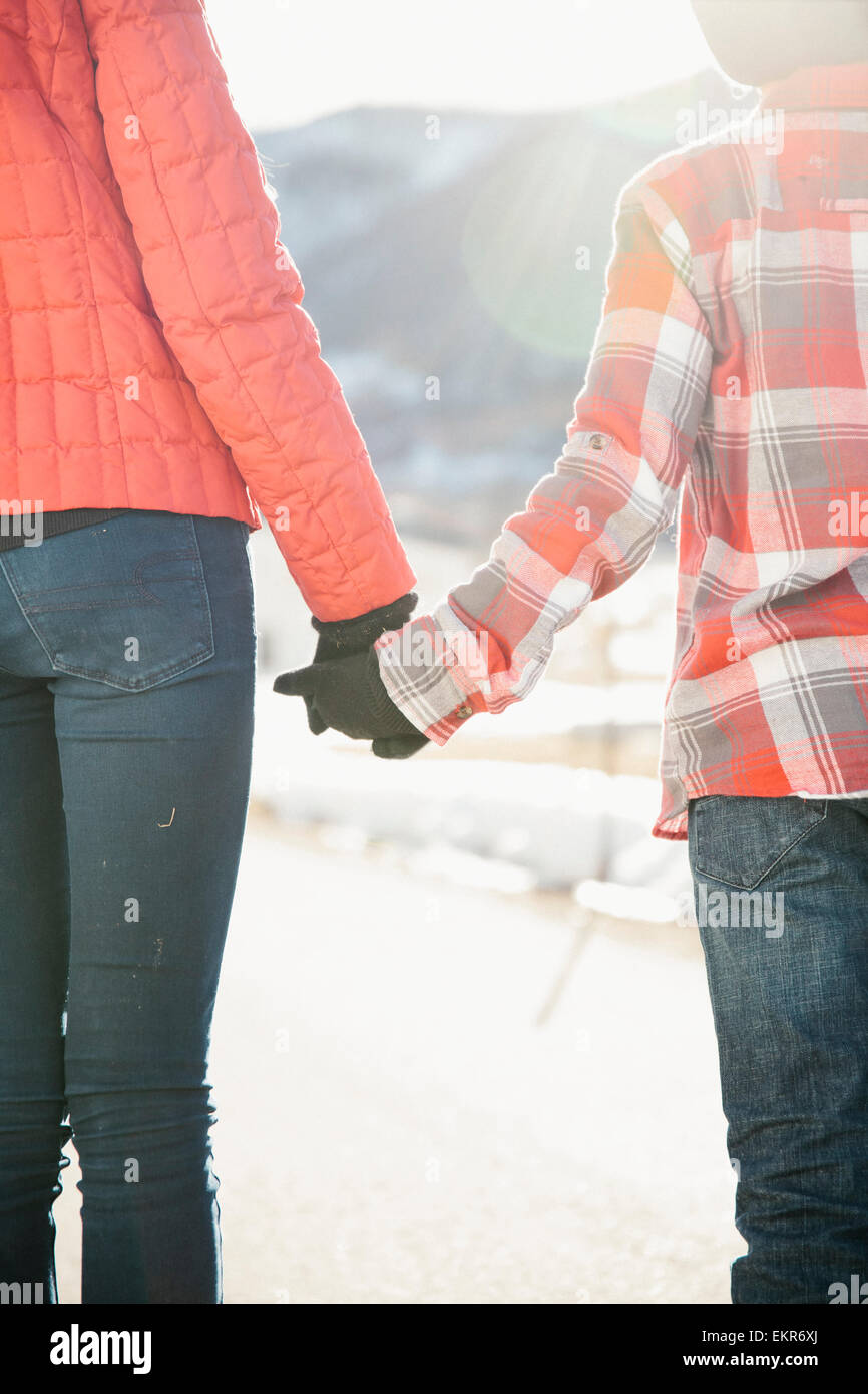 Due bambini per mano e guardando sopra un paesaggio invernale. Foto Stock