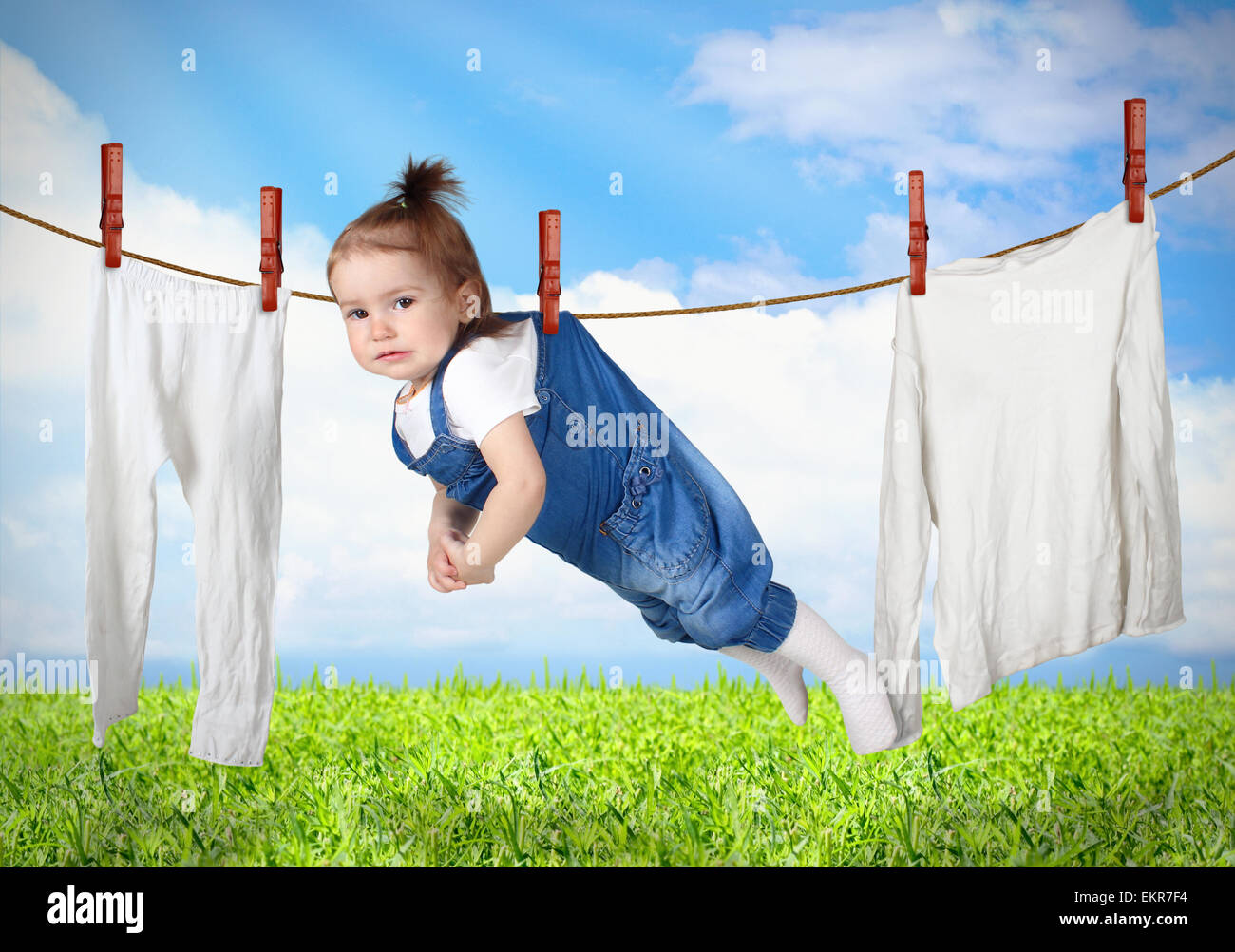 Funny bambino appeso sulla linea di abbigliamento, servizio lavanderia concetto creativo Foto Stock