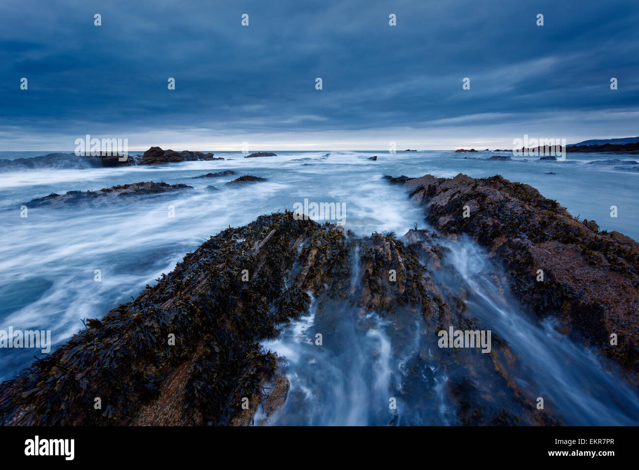 Grandi onde pastella la formazioni di roccia vicino a Cove, Scottish Borders, all'alba. Foto Stock