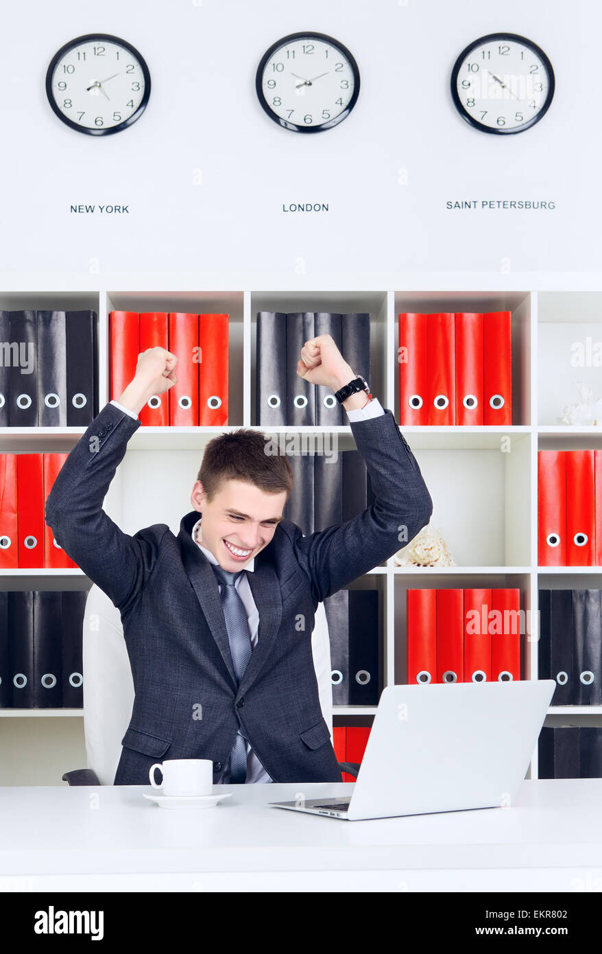 Fiducioso giovane impreditore trionfo guardando al laptop Foto Stock