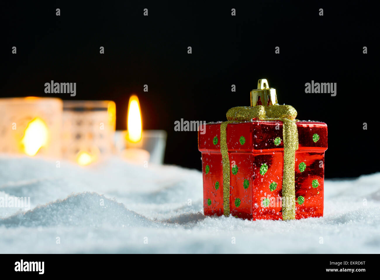 Decorazione di Natale presente sulla neve e candele Foto Stock