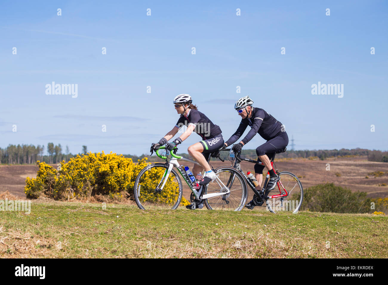 Una femmina e maschio ciclista competere nella nuova foresta dimenare evento sportivo su una soleggiata domenica di primavera Foto Stock