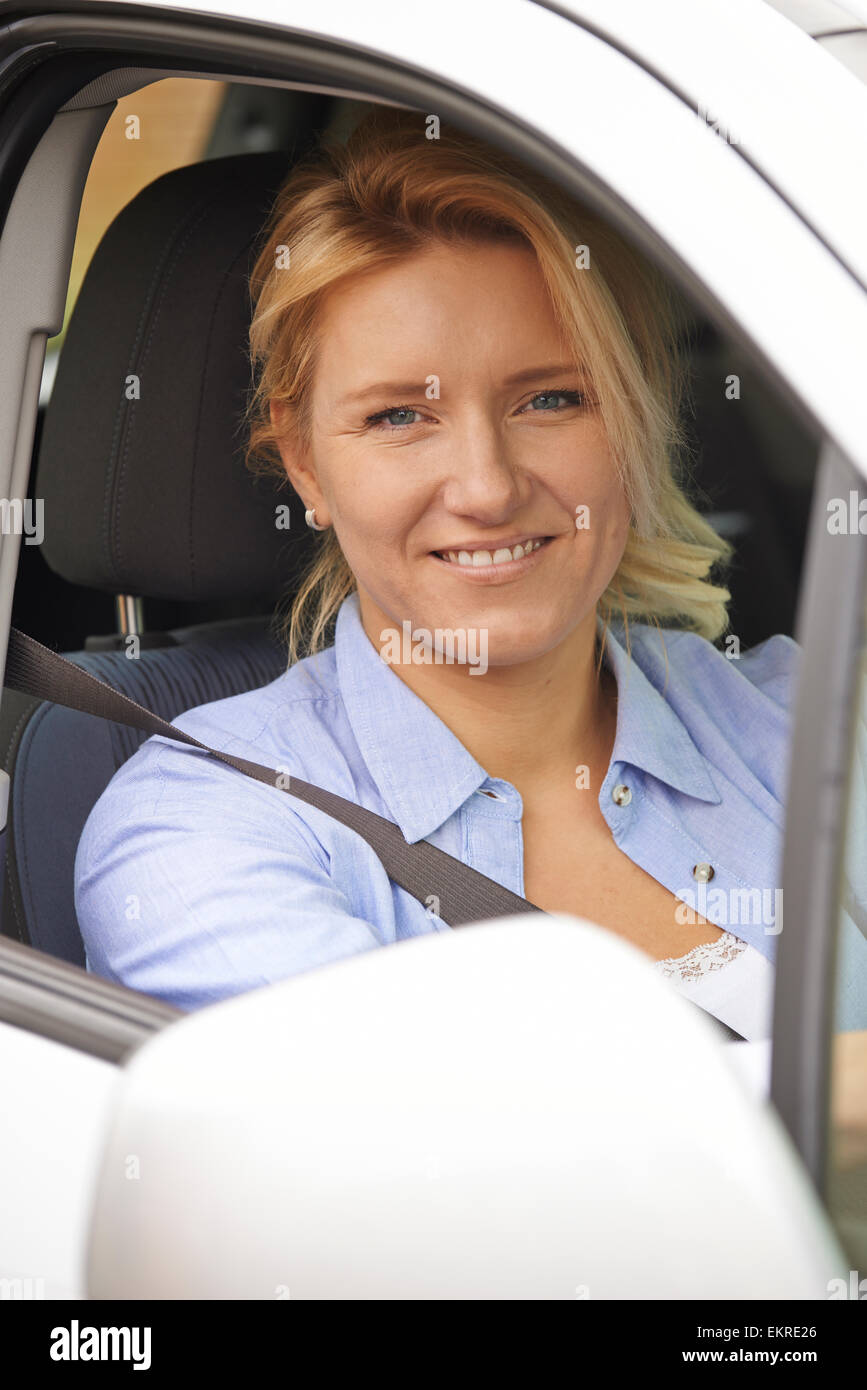 Ritratto di donna che guida guardando fuori della finestra Auto Foto Stock