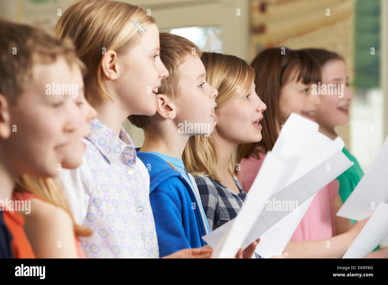 Un gruppo di bambini della scuola di cantare in coro scolastico Foto Stock