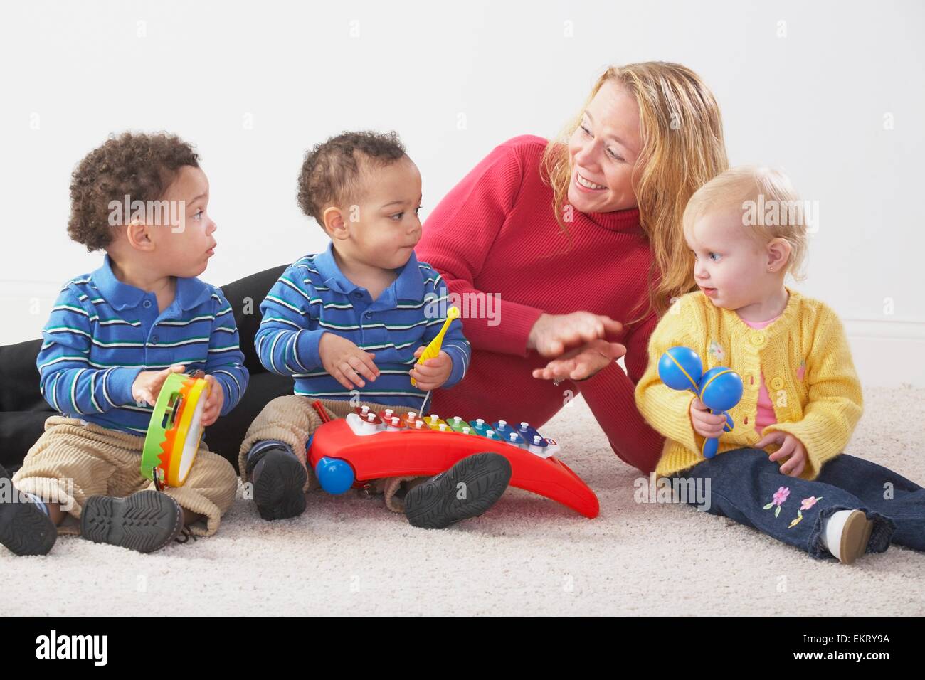 Knoxville, Tennessee, Stati Uniti d'America; una donna giocando con tre figli piccoli che hanno strumenti Foto Stock