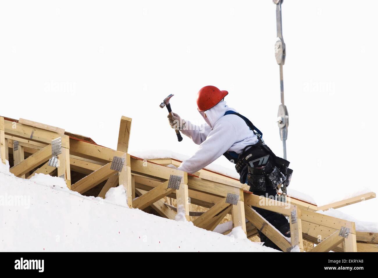 Calgary, Alberta, Canada; un lavoratore edile la costruzione di un tetto in inverno Foto Stock