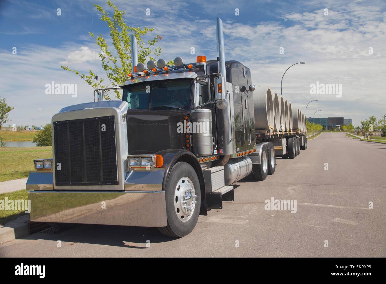 Grande carrello a semi-rimorchio trasporto tubo fognario; Edmonton, Alberta, Canada Foto Stock