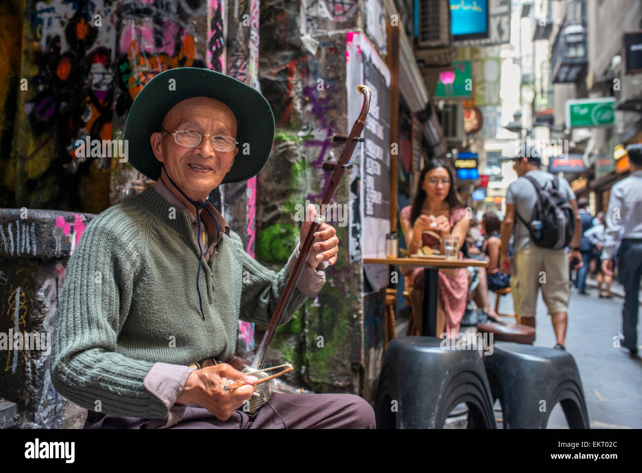 Un suonatore ambulante suona con un tradizionale cinese Erhu fiddle a Melbourne il luogo centrale café strip Foto Stock