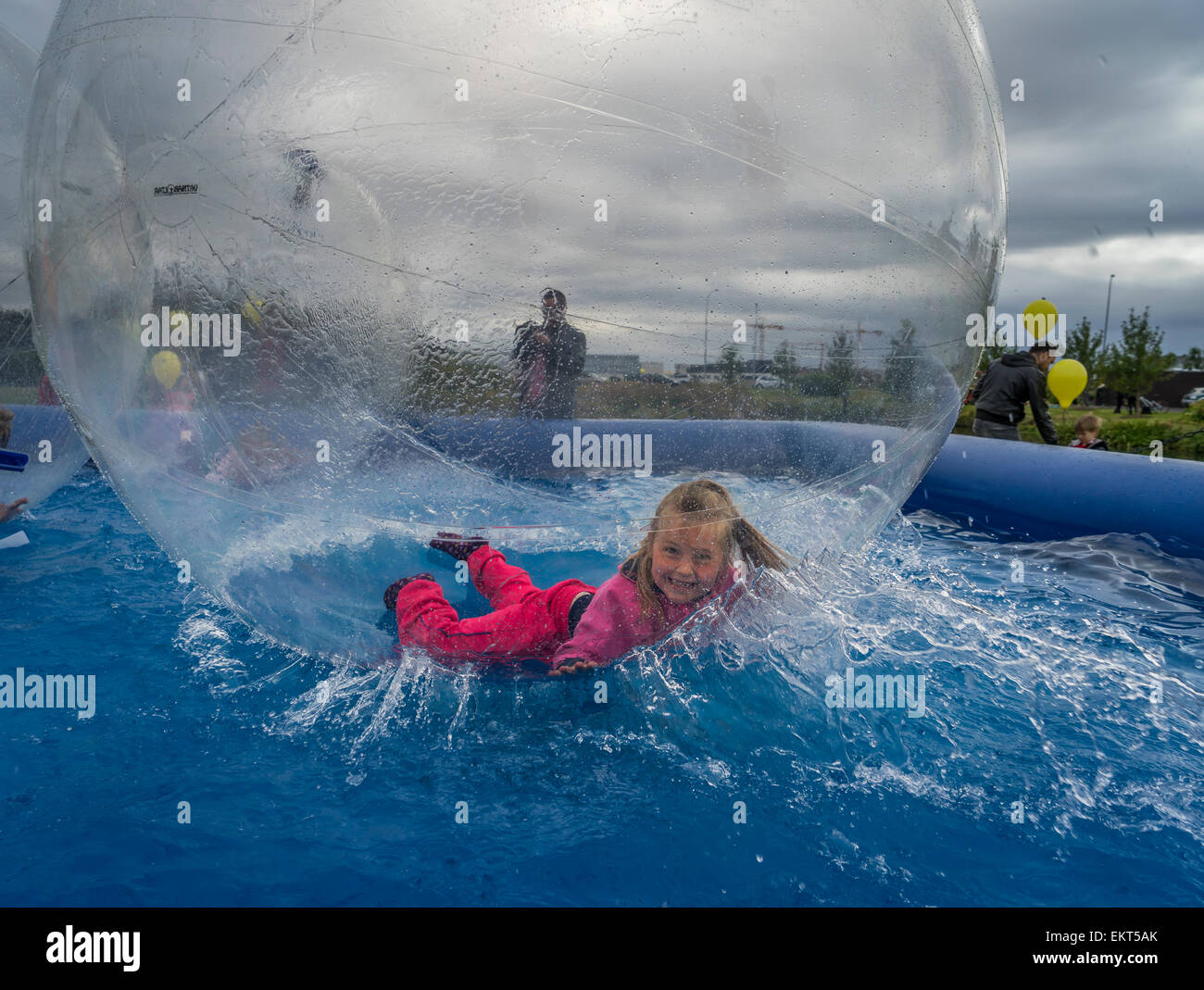 Giovane ragazza in un gigante di vedere attraverso la sfera gonfiabile noto come 'acqua walking balls", il summer festival, Reykjavik, Islanda Foto Stock