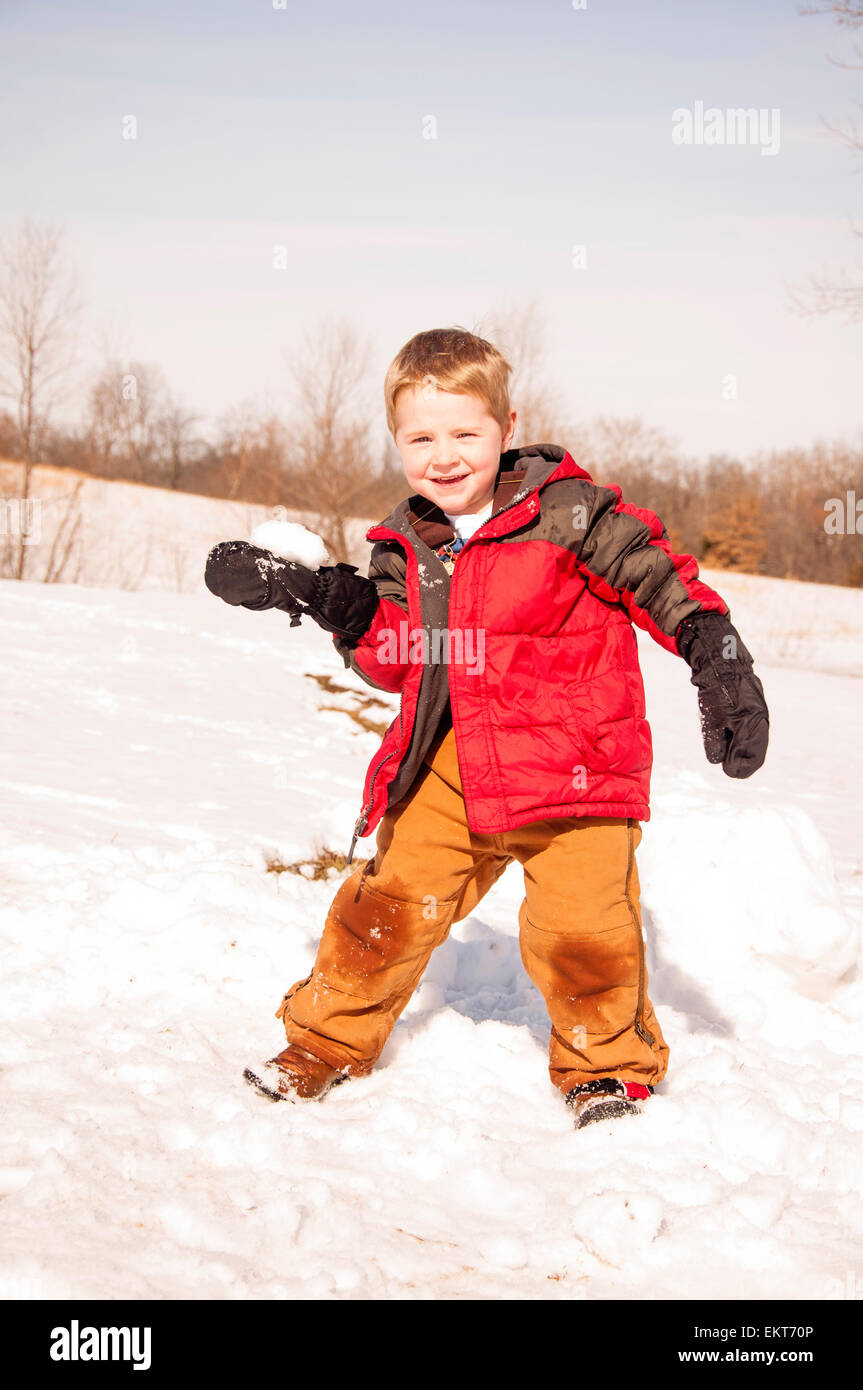 Ragazzo pronto a lanciare palle di neve Foto Stock