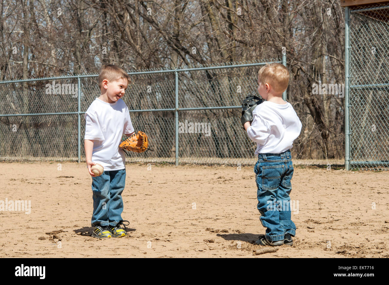 Due ragazzi a giocare a baseball di cattura e di conversazione Foto Stock