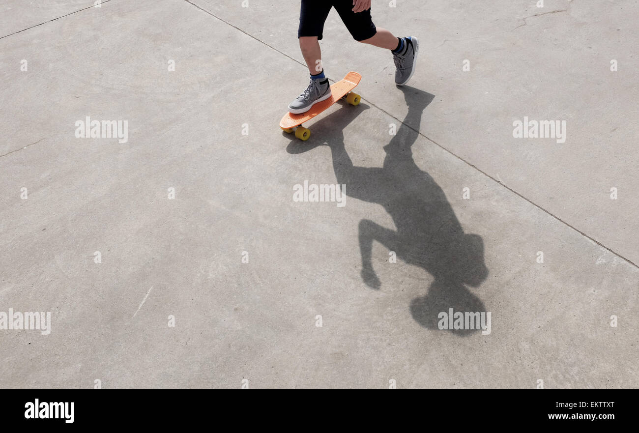 Ombra di un ragazzo su uno skateboard a skate park imparare a pattinare al sole Foto Stock