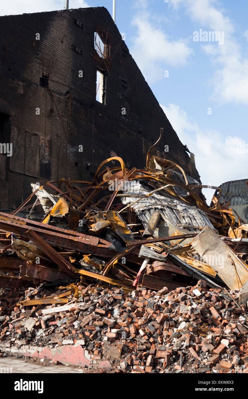 Fire danneggiato edificio con parete esterna rimanendo in piedi e il crollo del tetto con travi e macerie accatastate Cardiff Wales UK Foto Stock