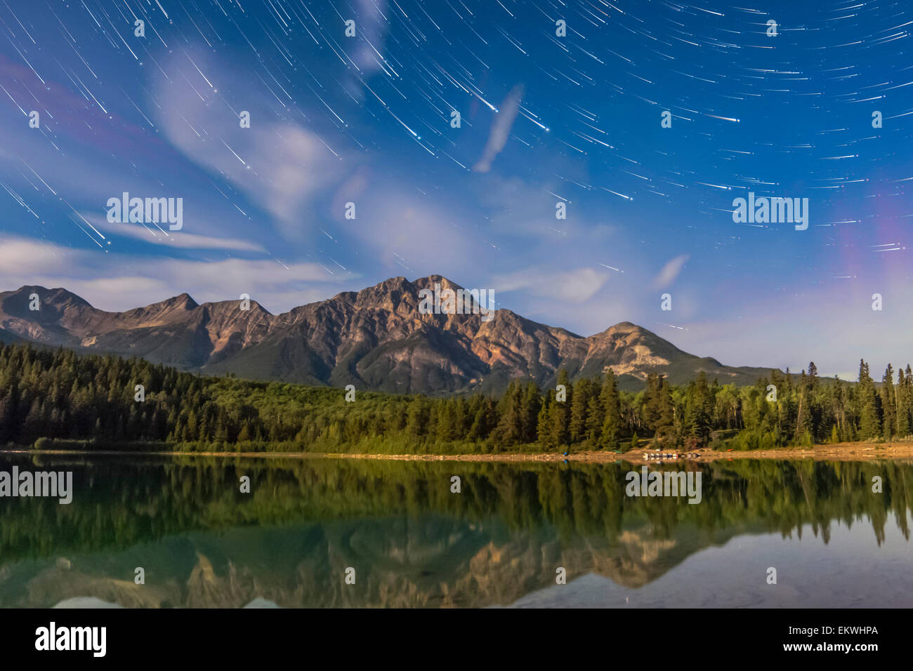 Tracce stellari su Patricia Lago Piramide e di montagna nel Parco Nazionale di Jasper, Alberta, Canada. Moonlight fornisce la illuminatio Foto Stock
