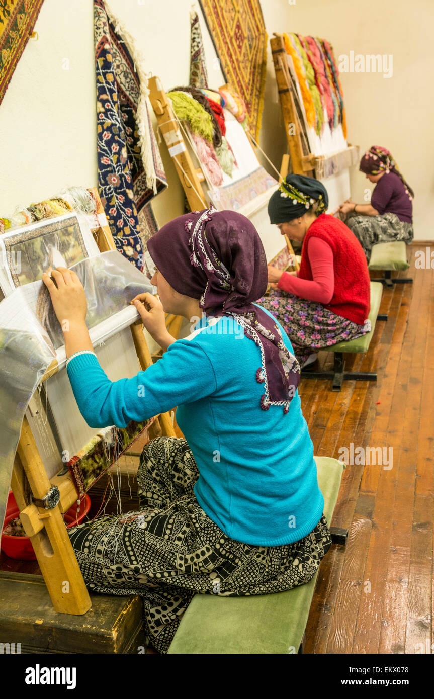 Le donne turche tradizionali di tessitura a mano di tappeti, nei pressi di Antalya, regione mediterranea, Turchia Foto Stock