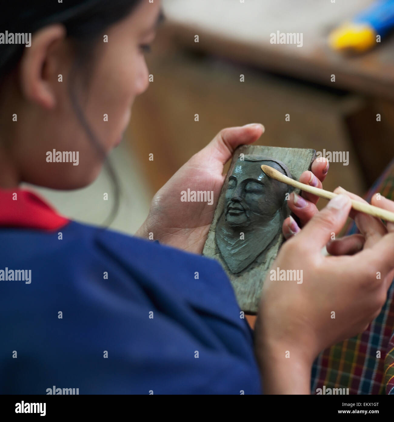 Una donna che lavora su una scultura di un volto umano; Thimphu Thimphu Distretto Bhutan Foto Stock