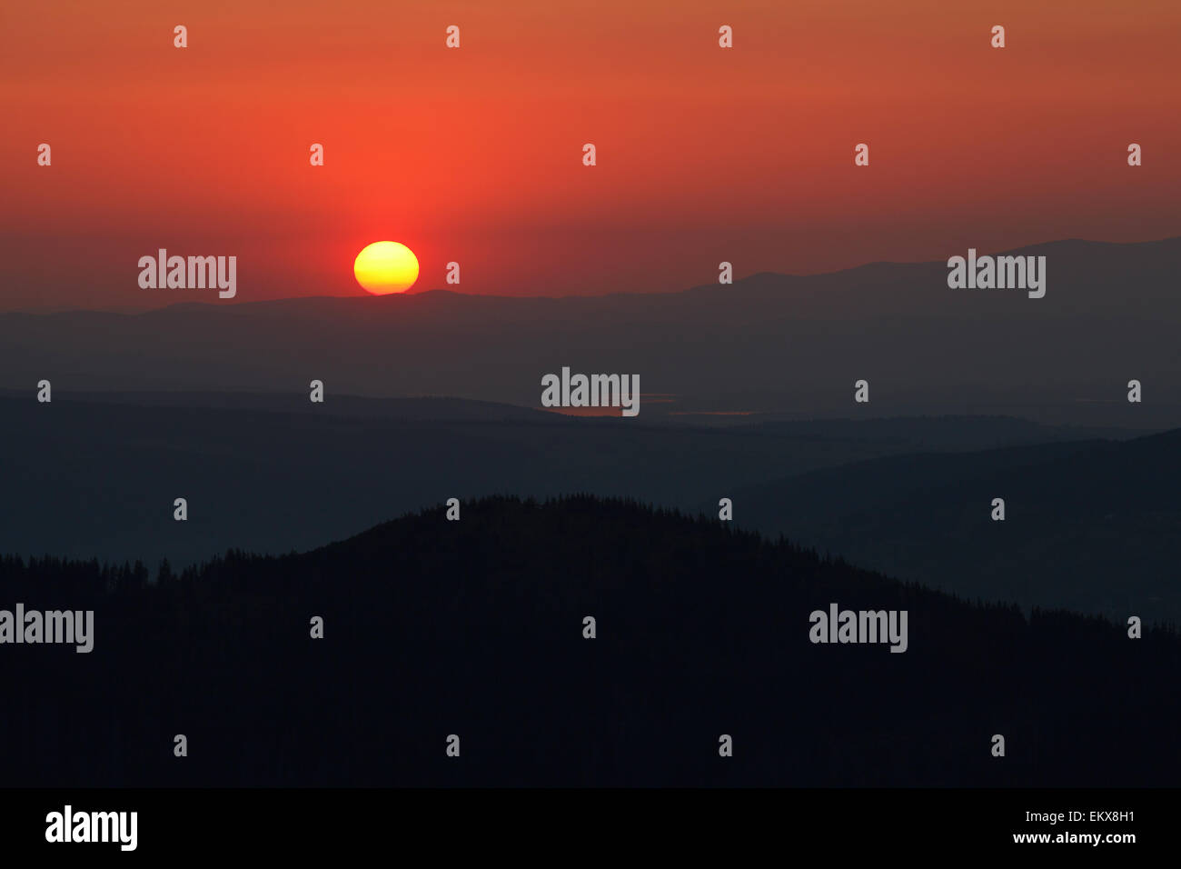 Impostazione di colore arancione Sun sulle lontane montagne, vista da alte montagne tatry Foto Stock