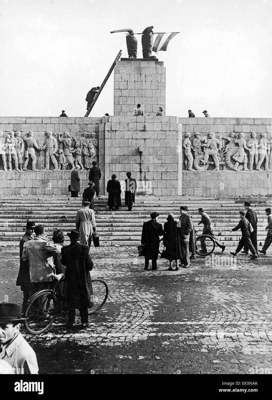 La rivolta ungherese 1956. Combattenti per la libertà che batte bandiera da gli stivali di tutto ciò che è stato lasciato dello statuto di Stalin a Budapest. La statua che era un dono di Joseph Stalin dal popolo ungherese del suo settantesimo compleanno. La statua è stata tirata in giù Foto Stock